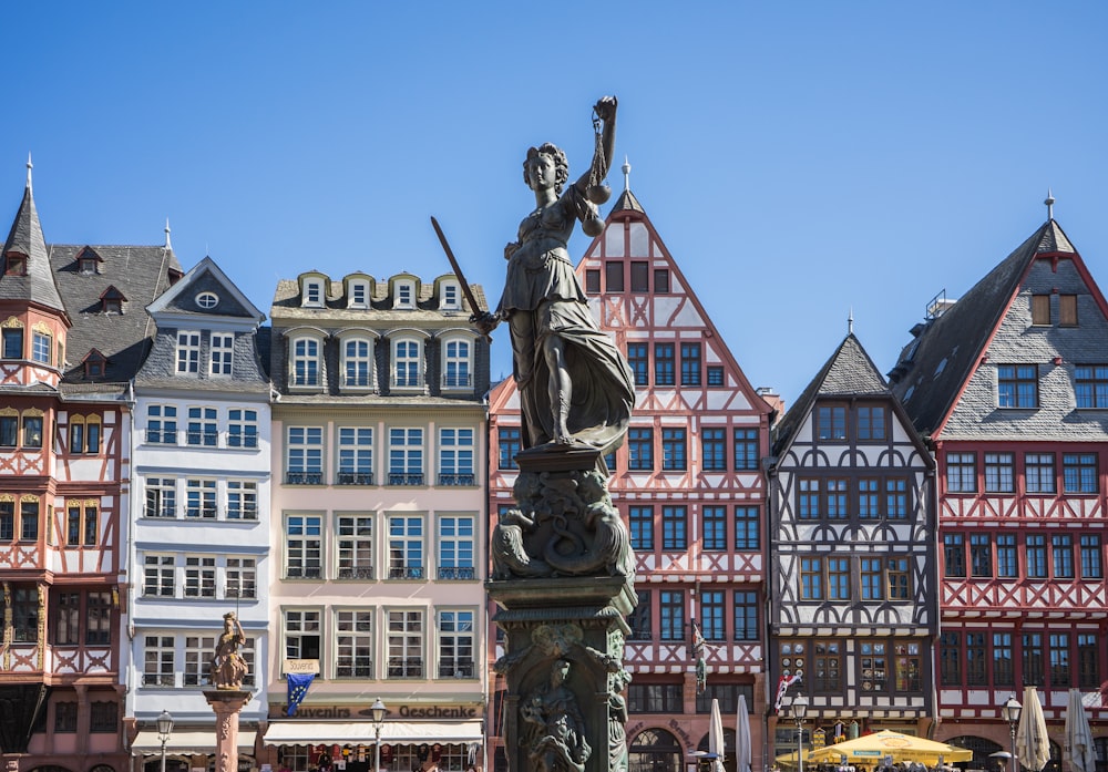 a statue in front of a row of buildings