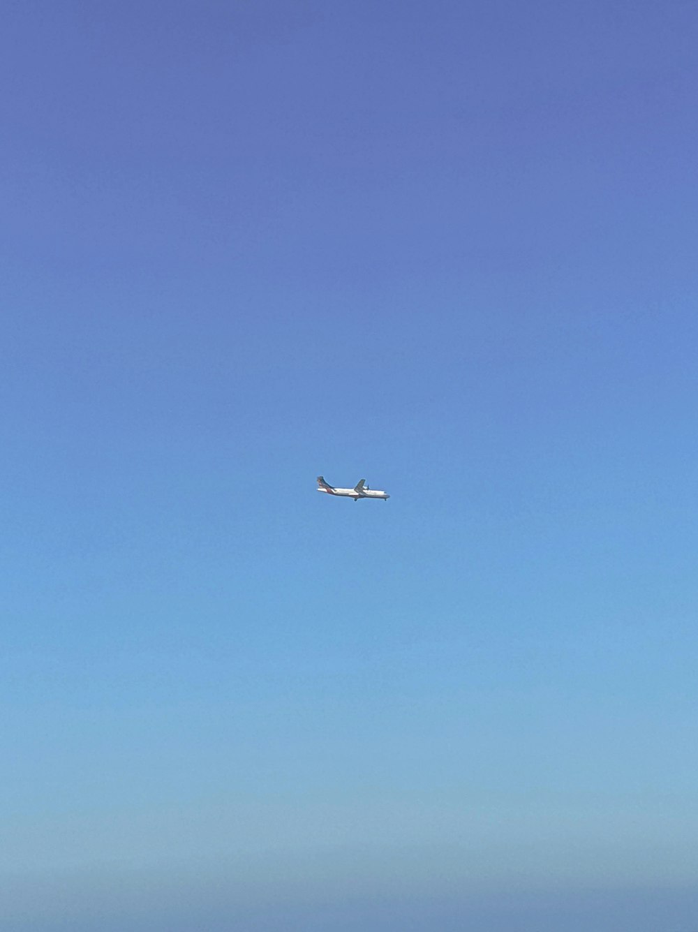 an airplane is flying in the blue sky
