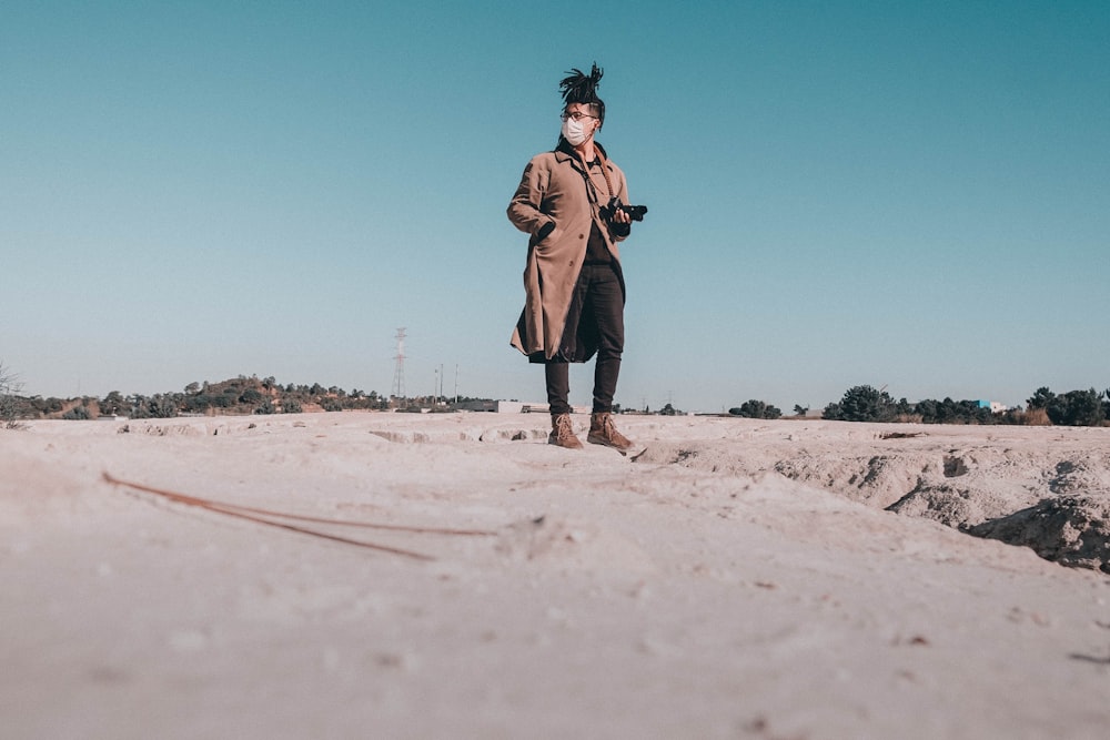 a person wearing a mask standing in the sand