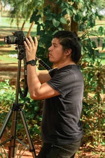 A person setting up a tripod in a scenic outdoor location.