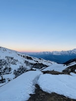 a snow covered mountain with a trail leading to the top