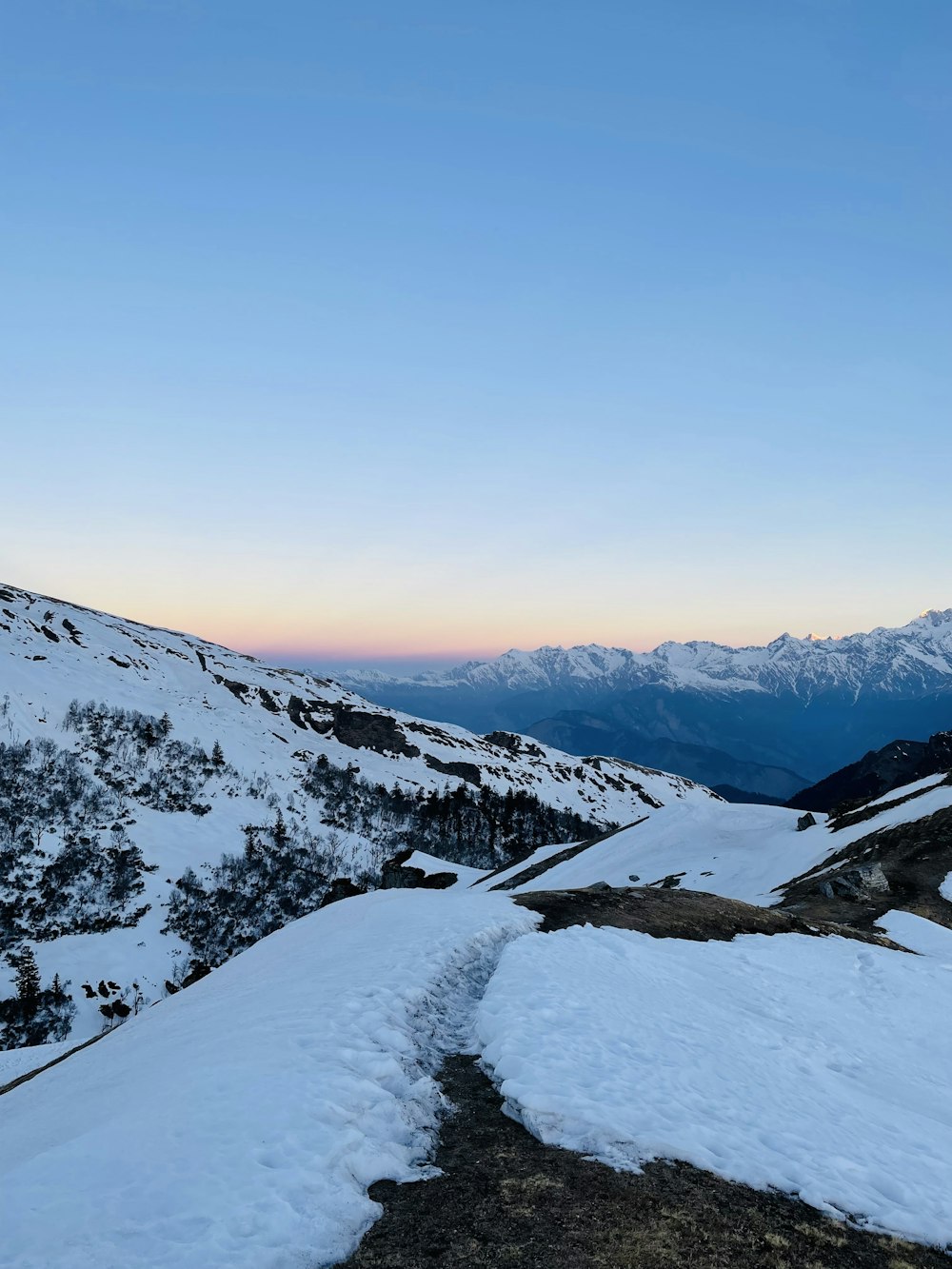 a snow covered mountain with a trail leading to the top