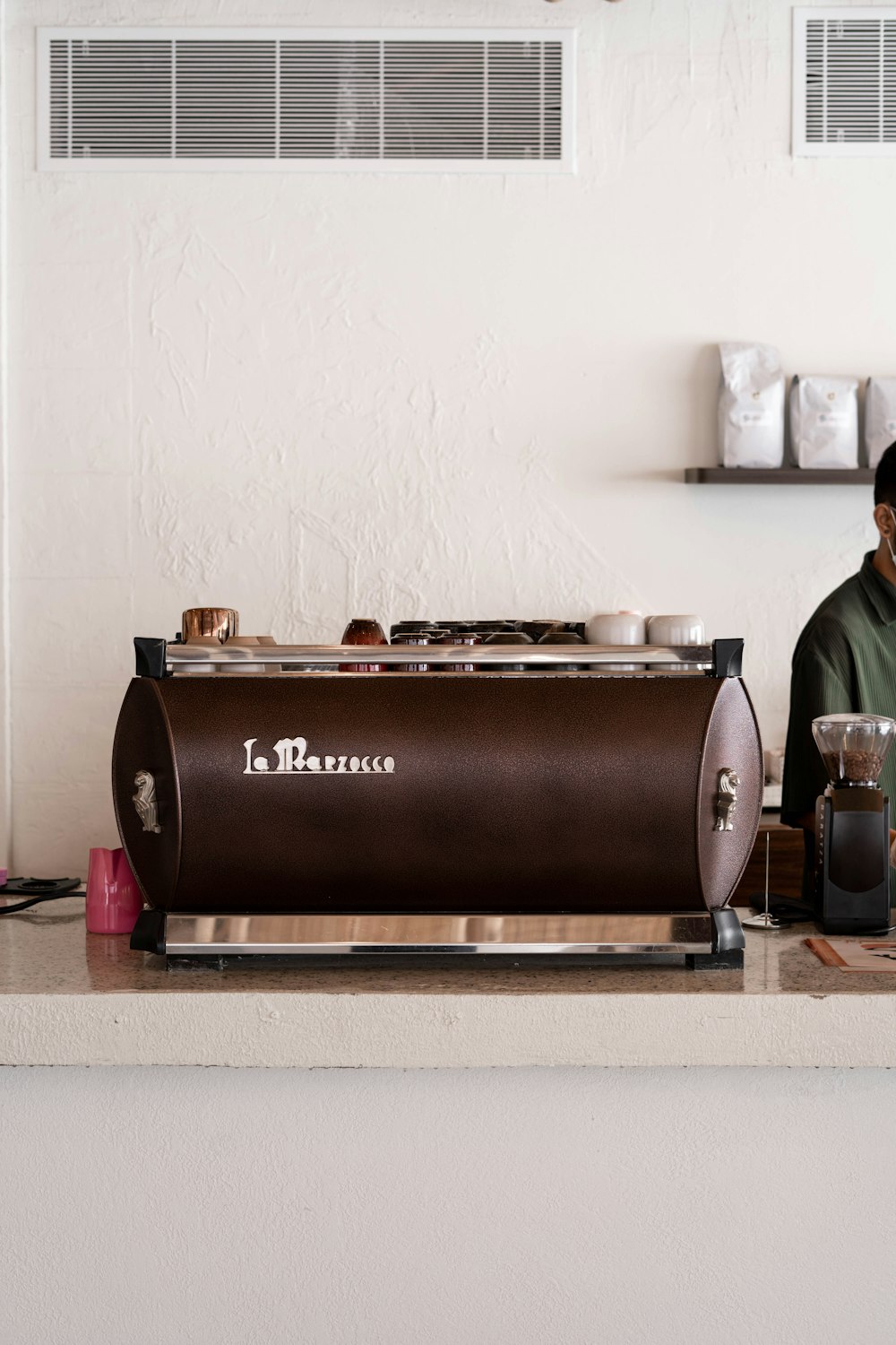 a man sitting in front of a coffee machine