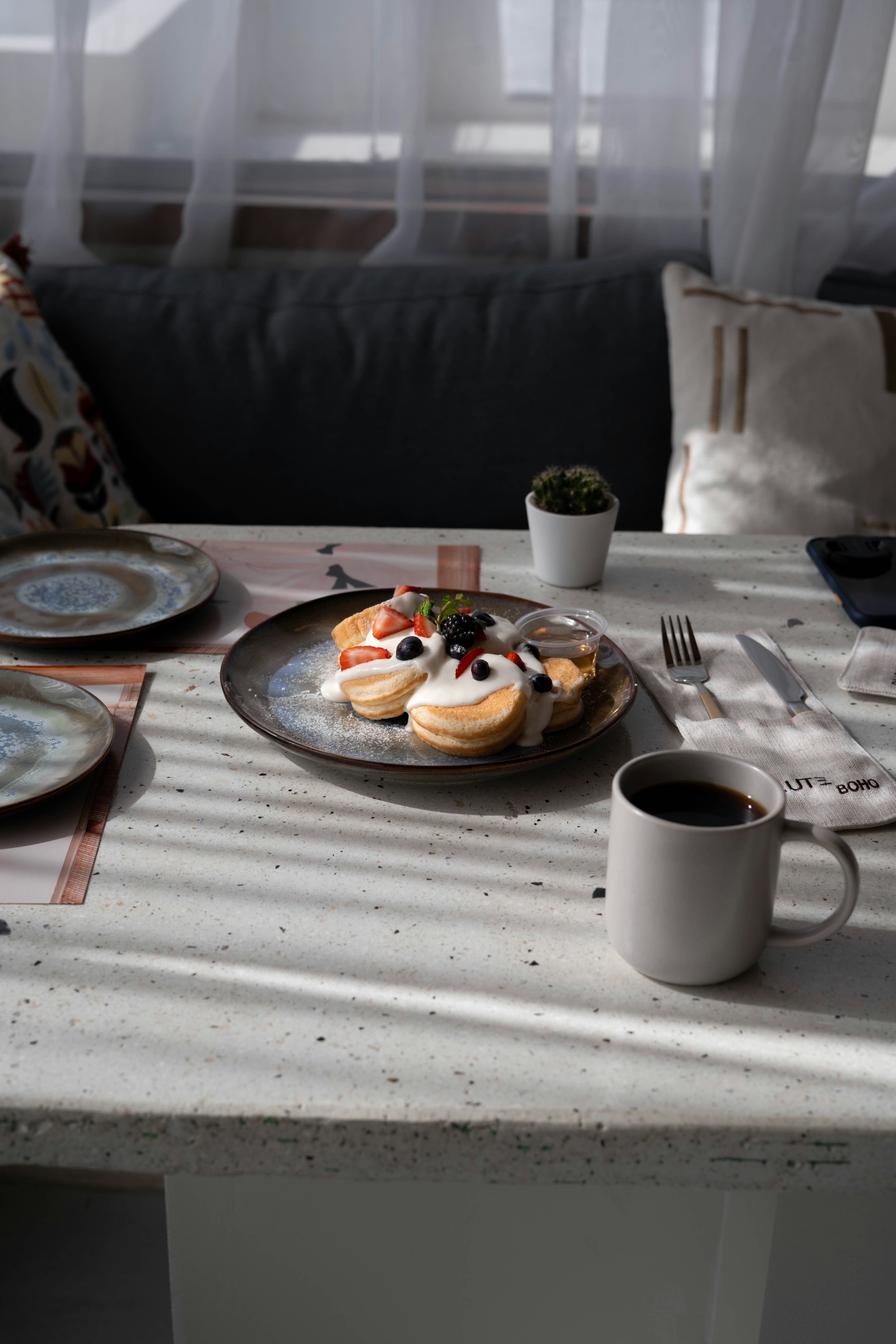 a plate of food sitting on a table next to a cup of coffee