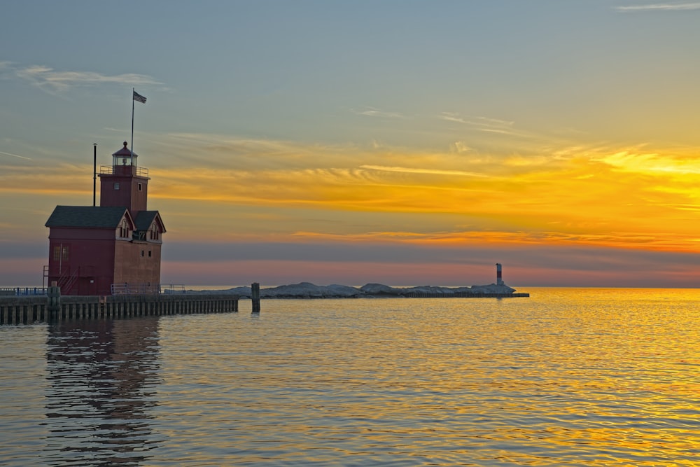 Ein roter Leuchtturm auf einem Pier neben dem Meer