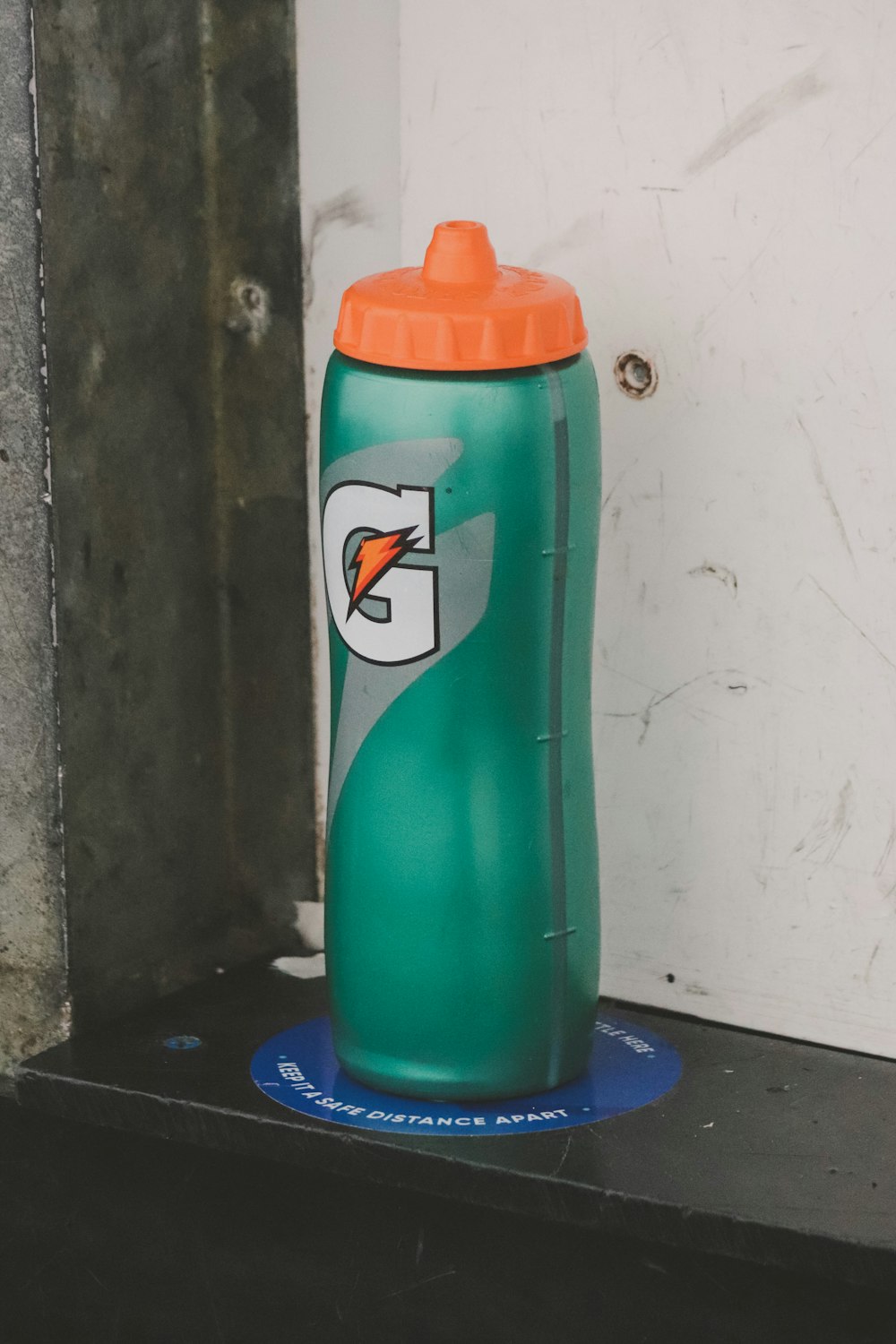 a green sports bottle sitting on top of a blue mat