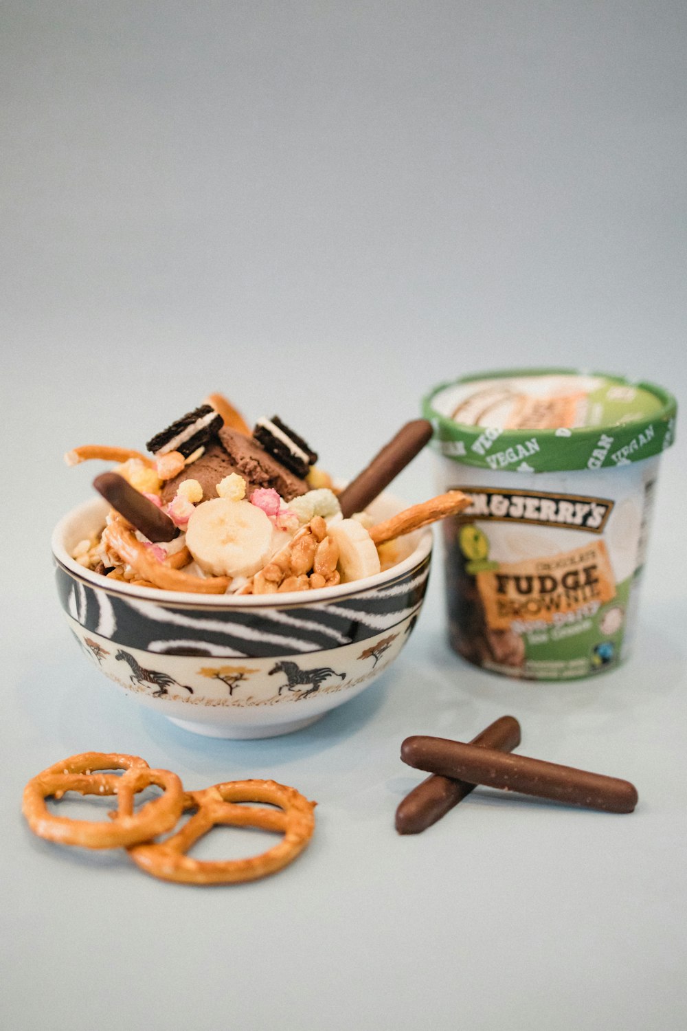 a bowl of cereal with pretzels and a cup of yogurt