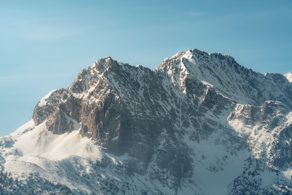 a snow covered mountain with a blue sky in the background