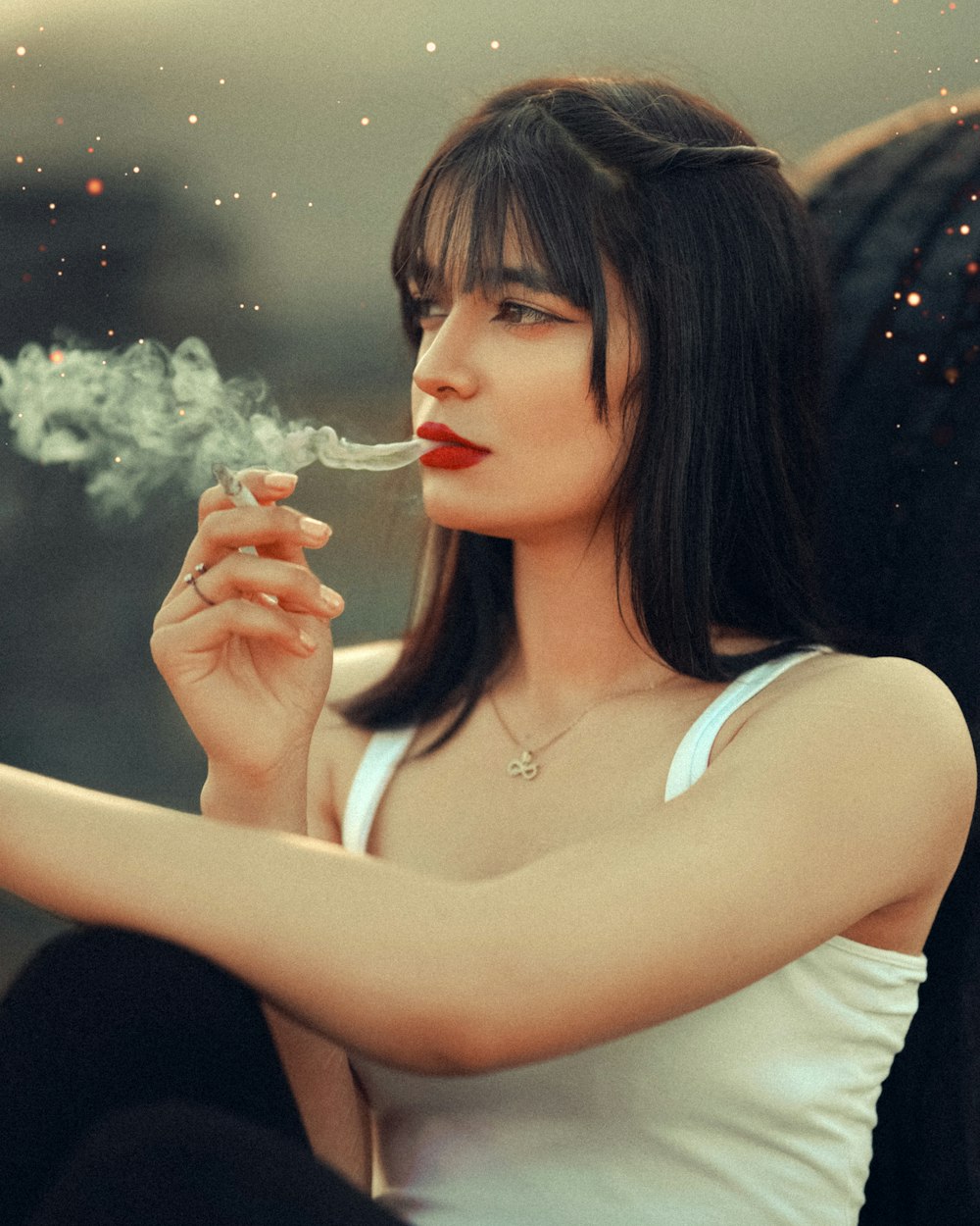 a woman sitting down smoking a cigarette