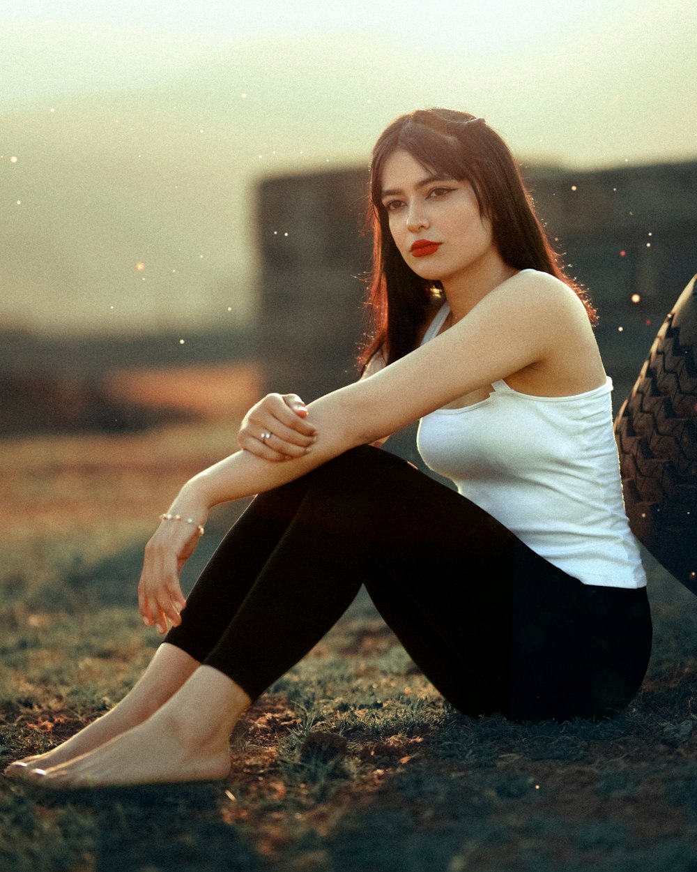 a woman sitting on the ground with her legs crossed