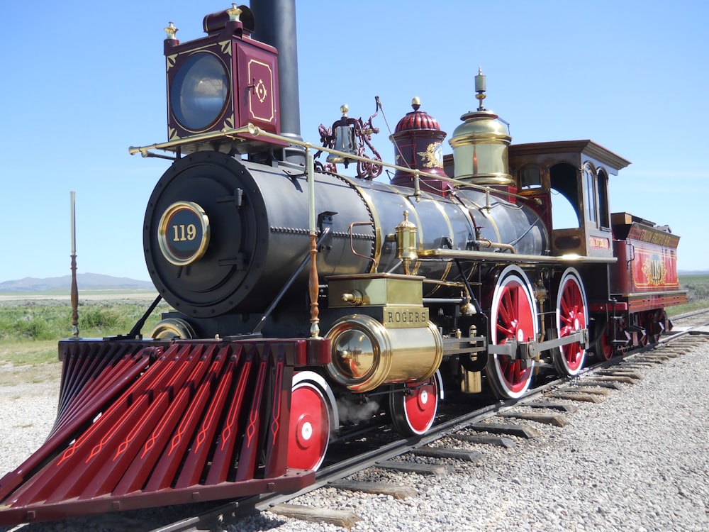 an old fashioned train is parked on the tracks