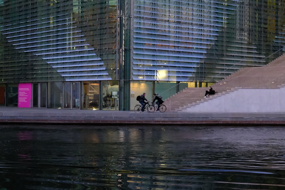 a couple of people riding bikes down a street