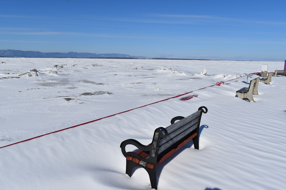 a bench sitting in the middle of a snow covered field