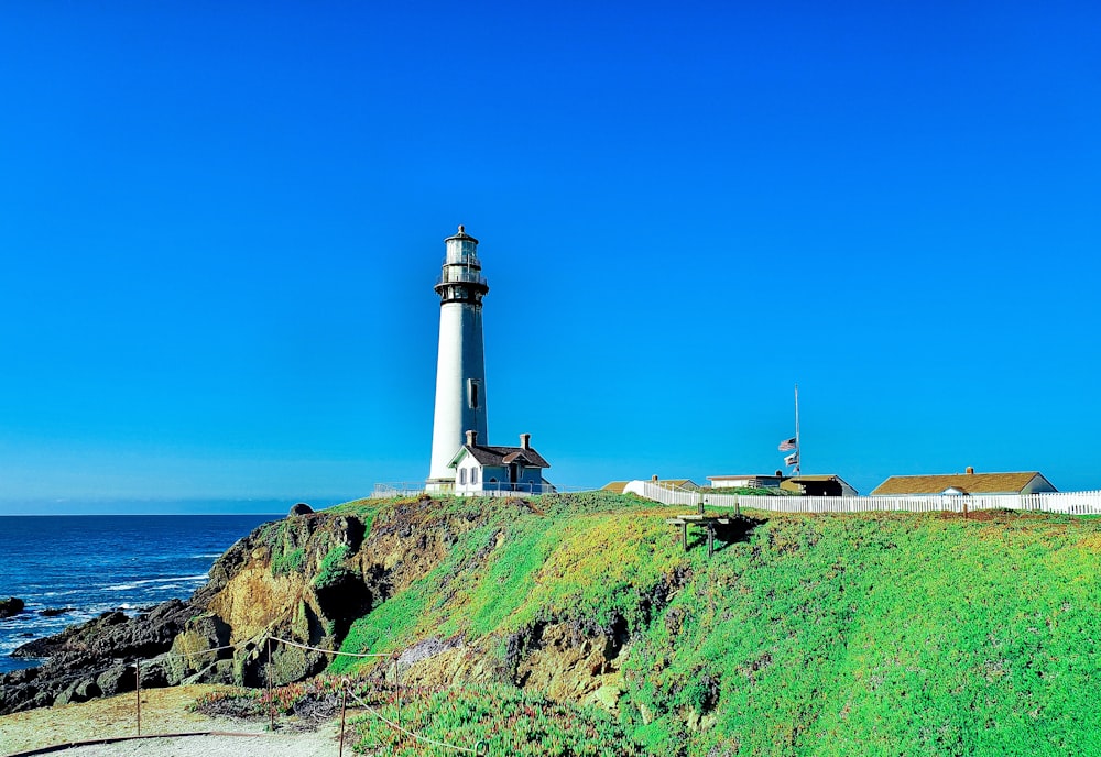 a light house sitting on top of a cliff next to the ocean