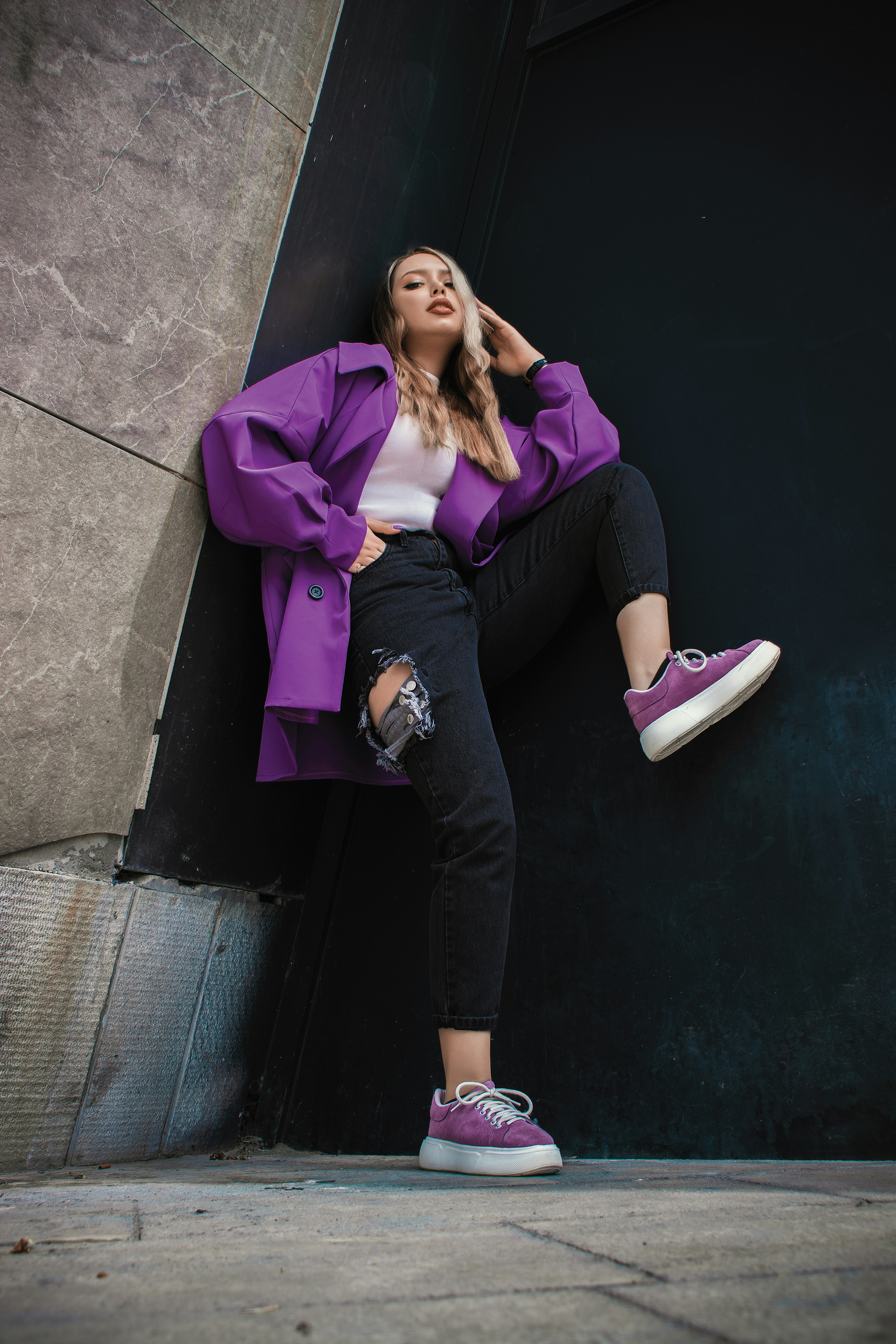 Una persona con zapatos morados y blancos de pie en una acera