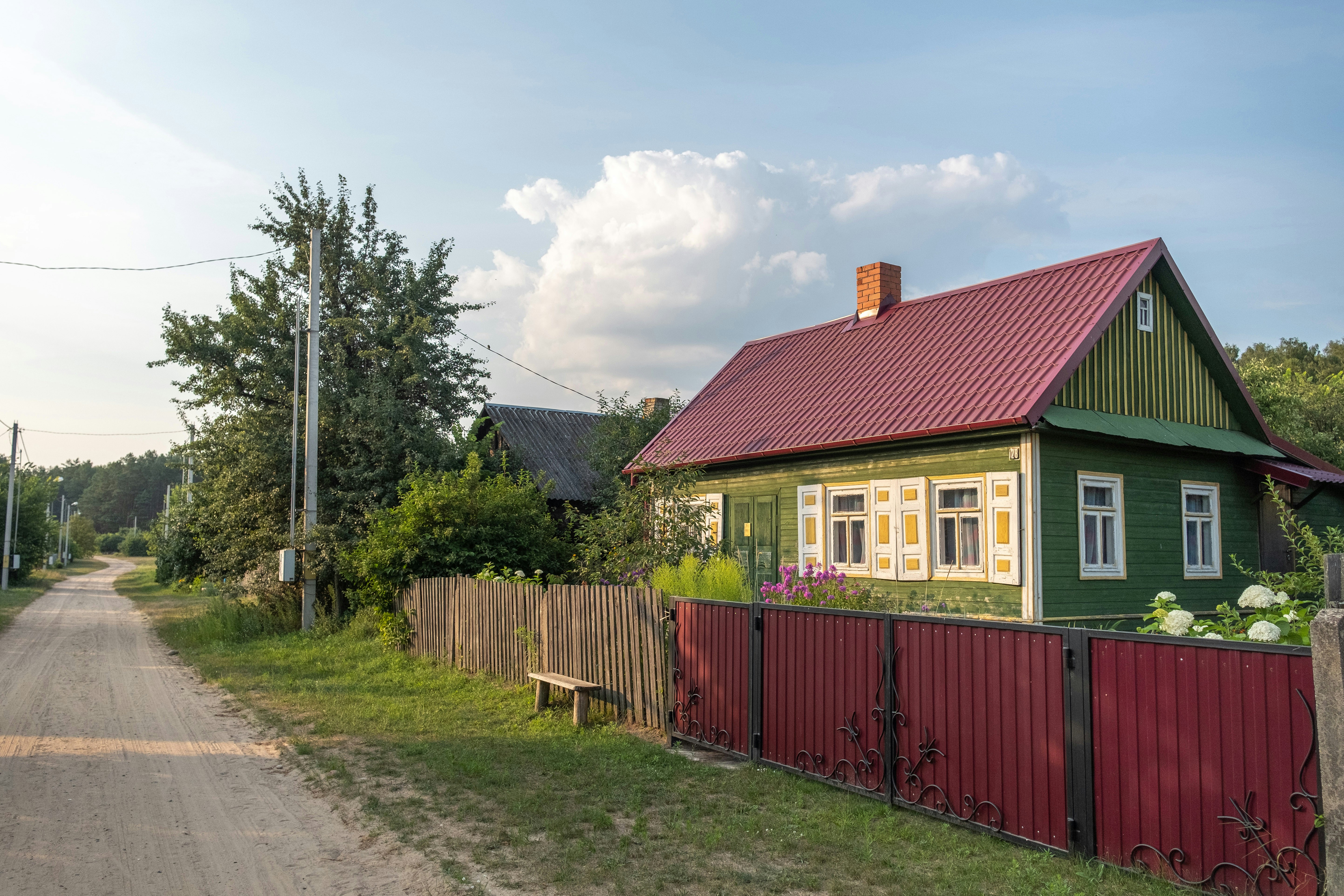 a small green house with a red roof