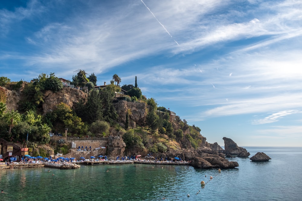 a beach on a hill with people swimming in the water