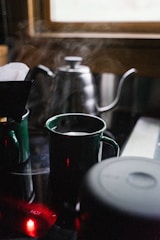 A cozy kitchen scene featuring a clean, modern mug filled with steaming coffee on a wooden table.