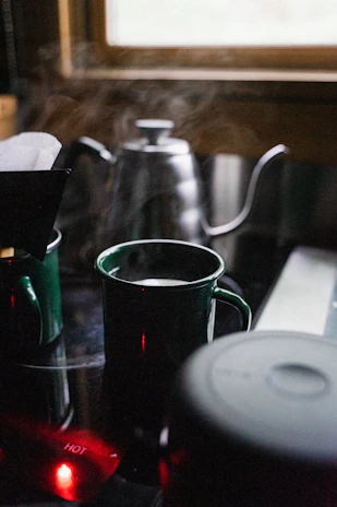 A cozy kitchen scene with a Frostara Thermo King tumbler steaming beside a morning window.