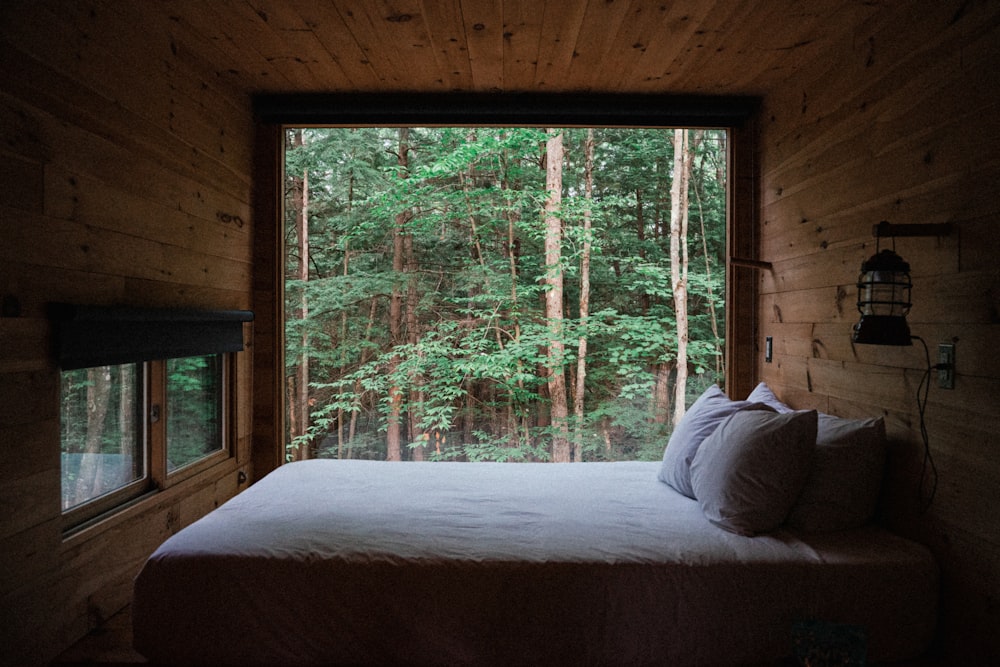 a bed sitting in a bedroom next to a window