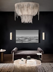 A beautifully decorated modern living room showcasing intricate wall art and elegant lighting.