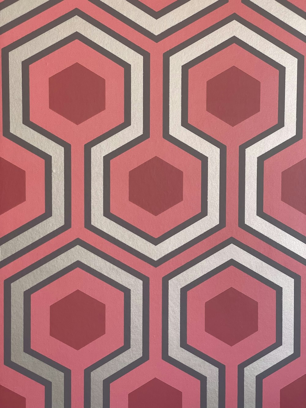 a red and grey wallpaper with a hexagonal pattern