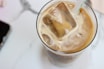 A refreshing iced coffee drink with ice cubes and a straw.