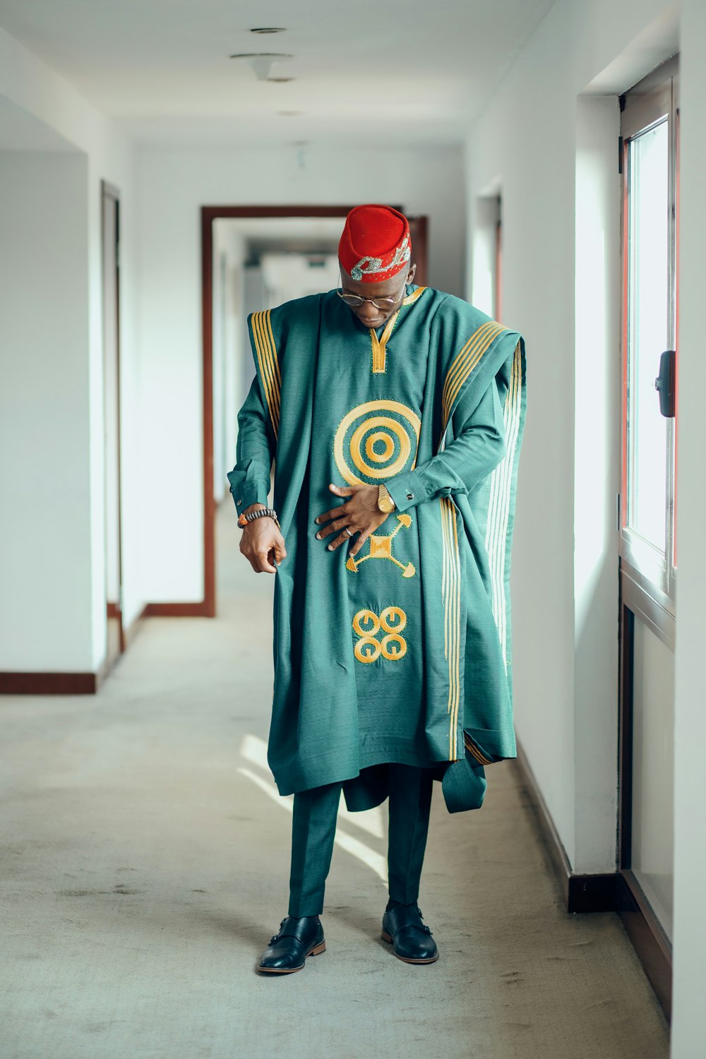 a man in a green outfit standing in a hallway