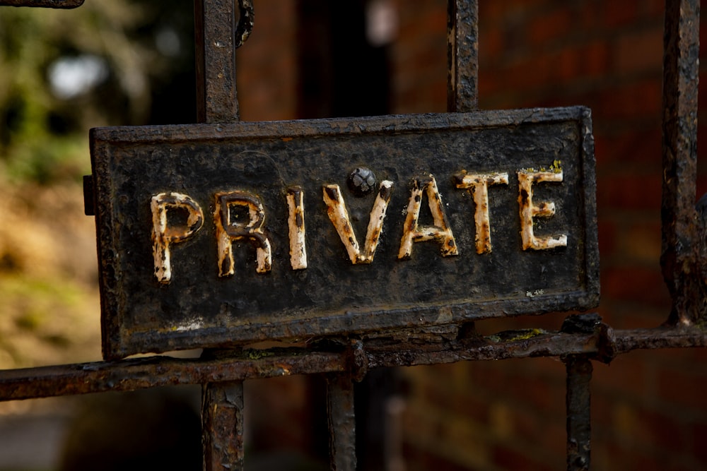 a sign that says private on a rusted gate