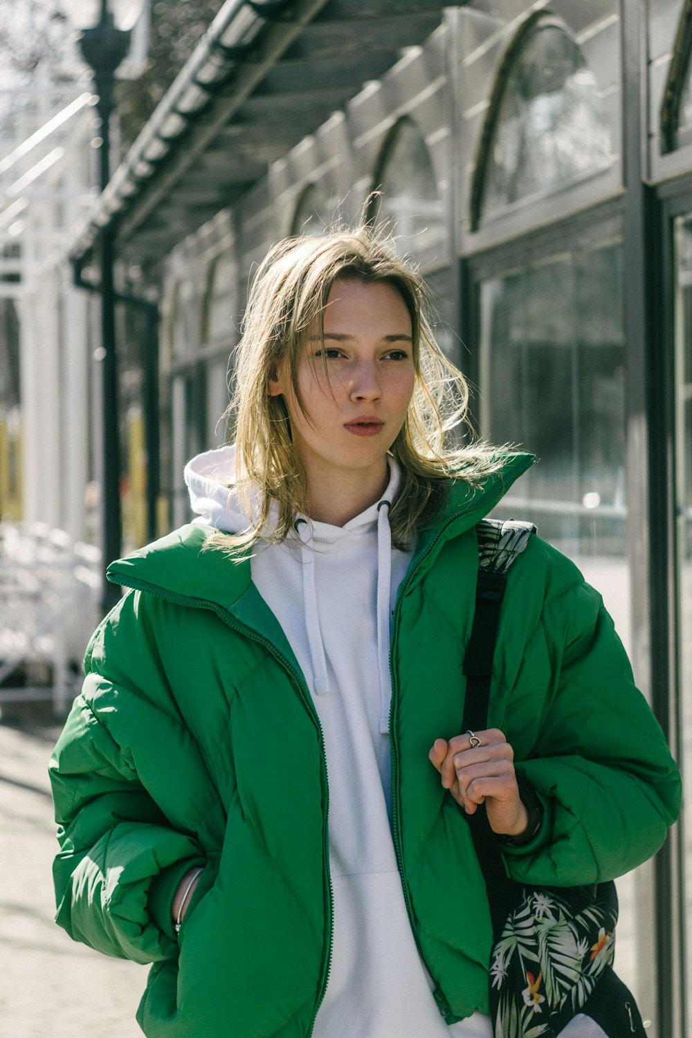 a woman wearing a green jacket and white shirt