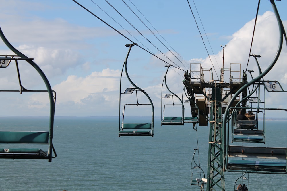 a group of people riding a ski lift over the ocean