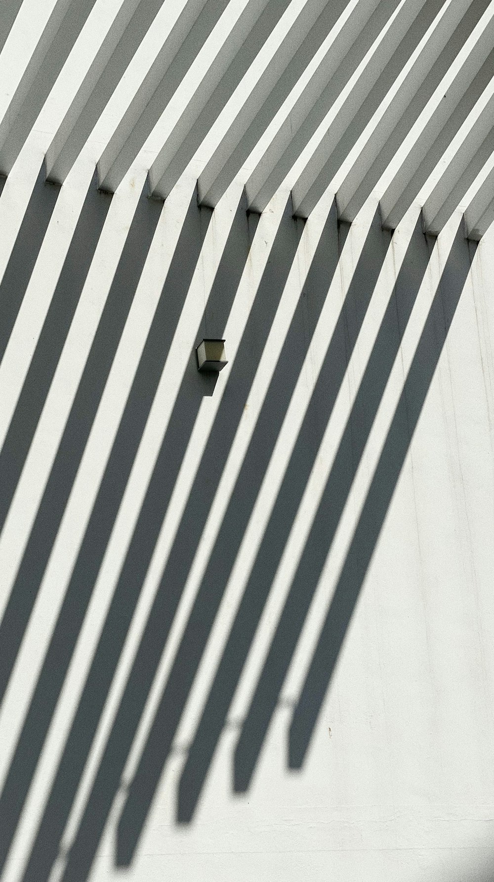 the shadow of a clock on the wall of a building