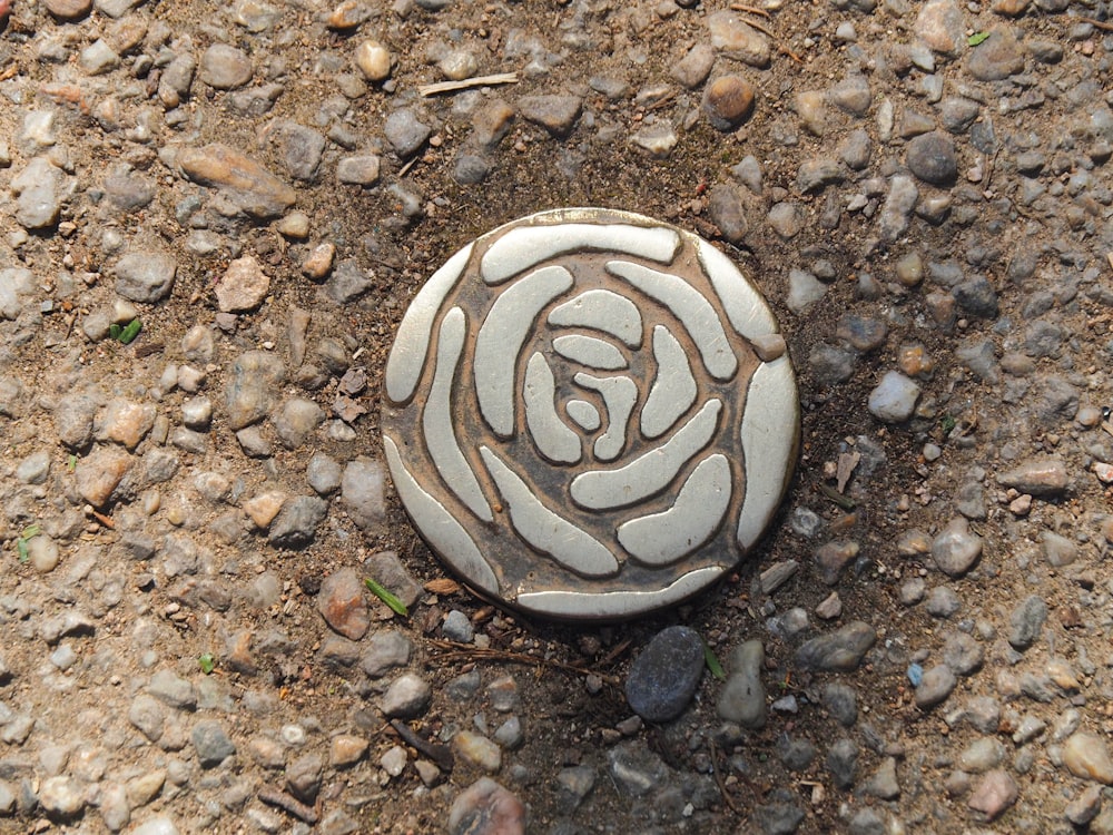 a stone with a rose on it laying on the ground