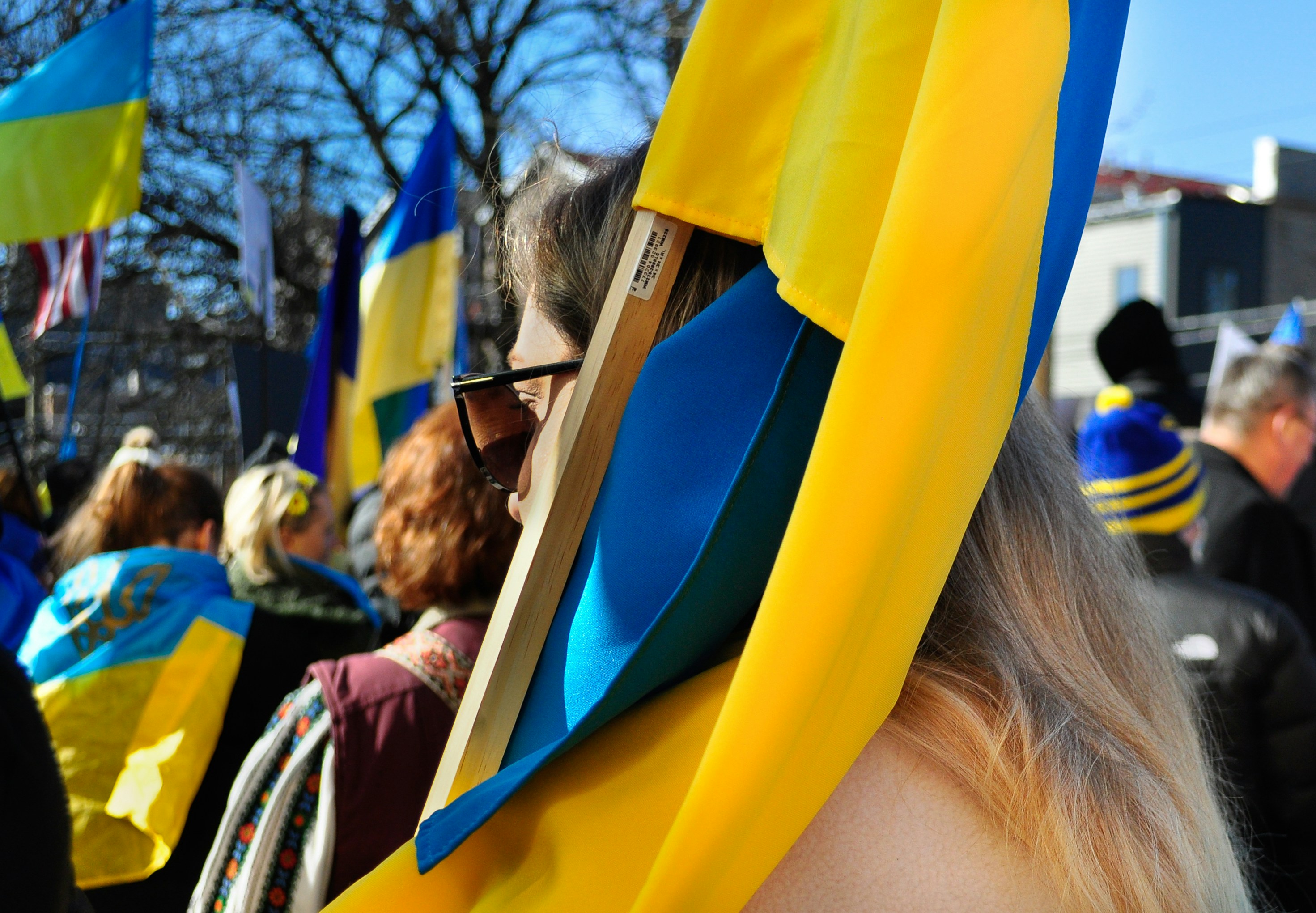 a group of people standing around each other holding flags