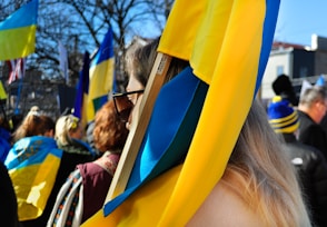 a group of people standing around each other holding flags
