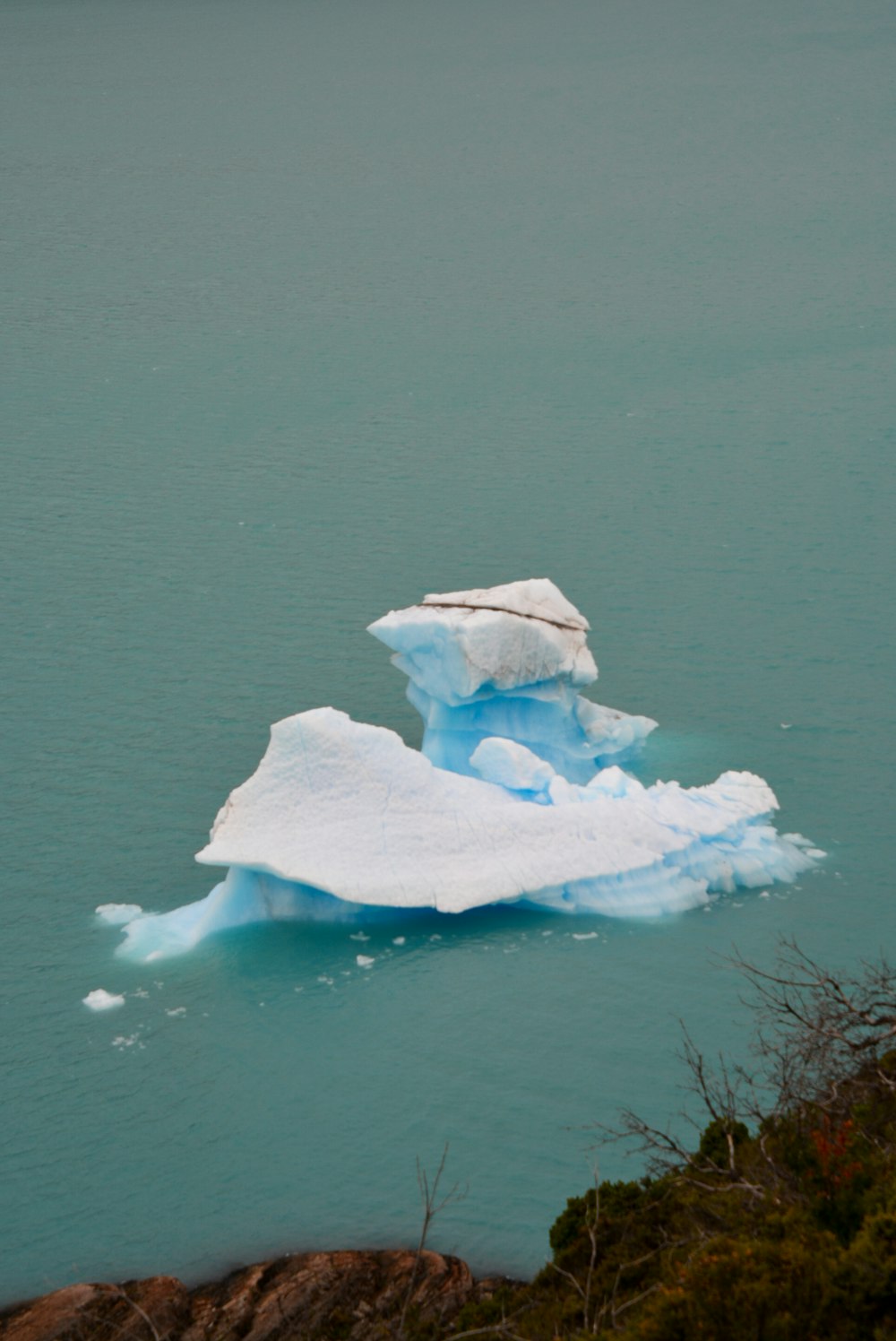 a large iceberg floating in the middle of a lake