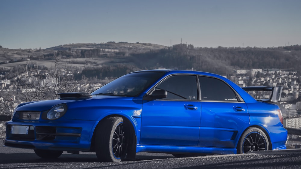 a blue car parked on the side of a road