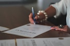 a woman writing on a piece of paper