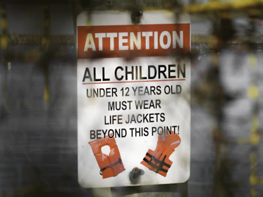 a sign on a pole that says attention all children under 12 years old must wear