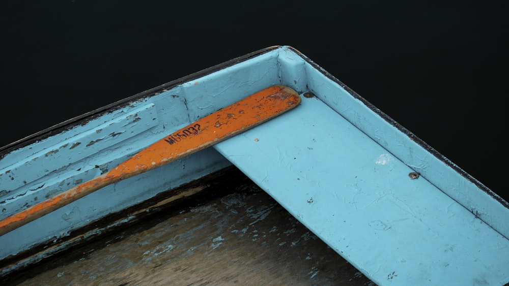 a blue boat with a rusted orange handle