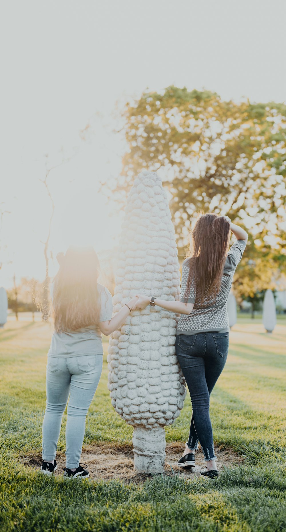 two women standing next to each other in a field