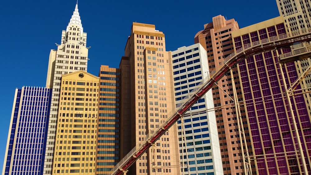 a crane is in the foreground of a row of tall buildings