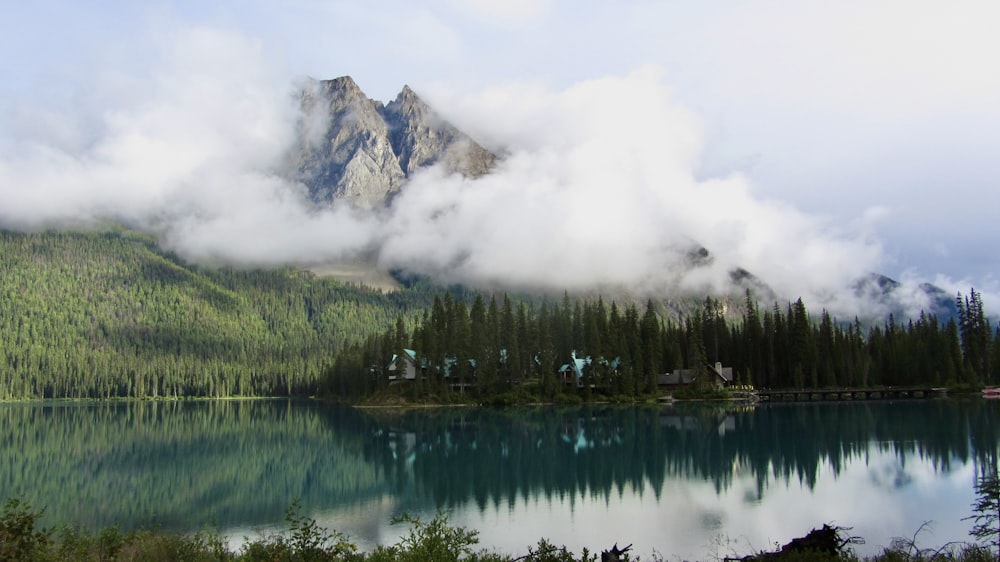 a lake surrounded by trees and a mountain in the background