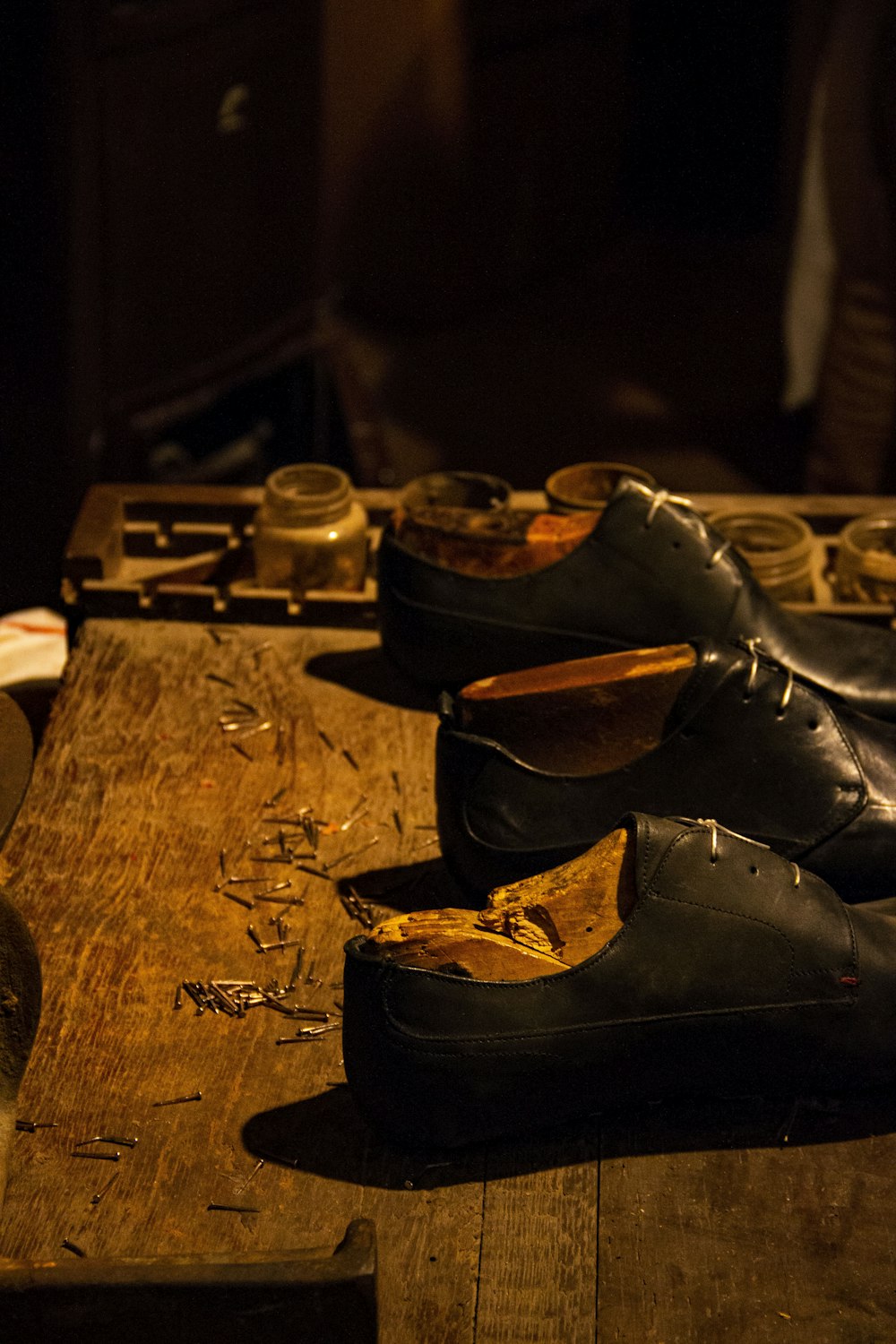 um par de sapatos pretos sentados em cima de uma mesa de madeira