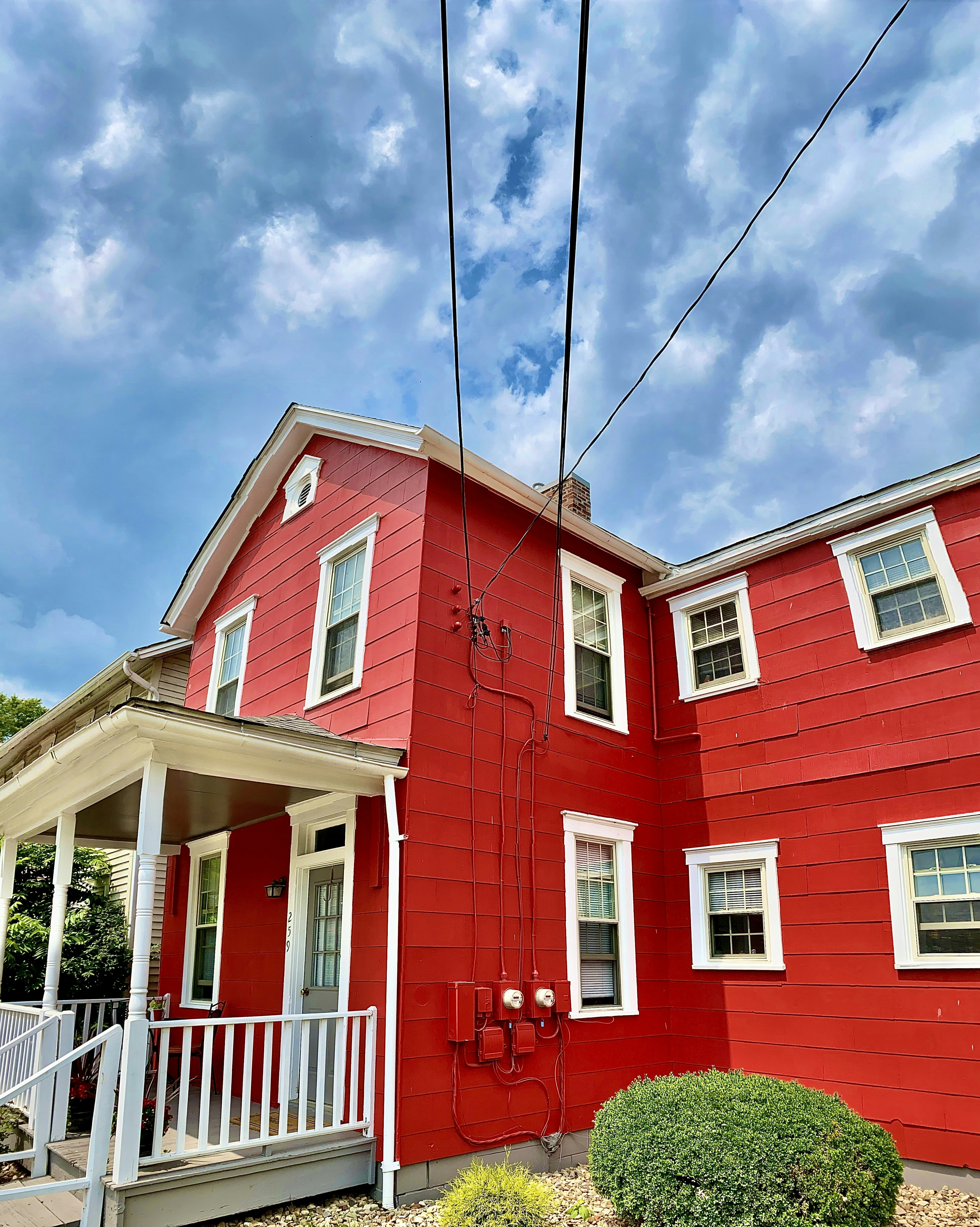 a red house with white trim and a white porch