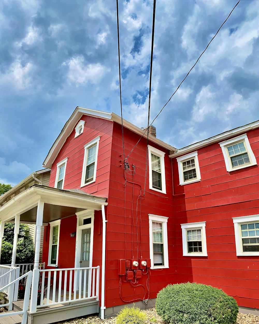 a red house with white trim and a white porch
