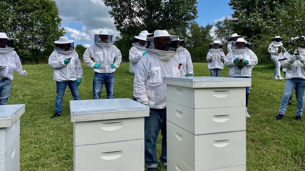 a group of men in bee suits standing in a field