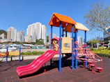 A vibrant indoor playground filled with colorful slides and happy children playing.