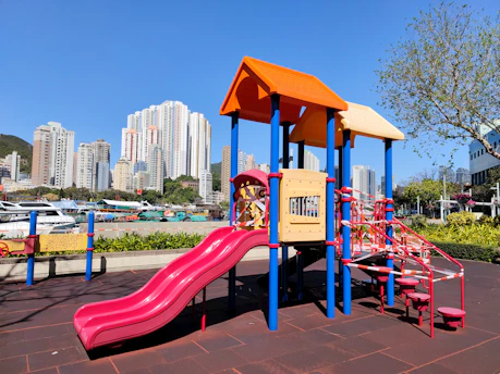 A vibrant indoor playground filled with colorful slides, climbing structures, and happy children playing together.