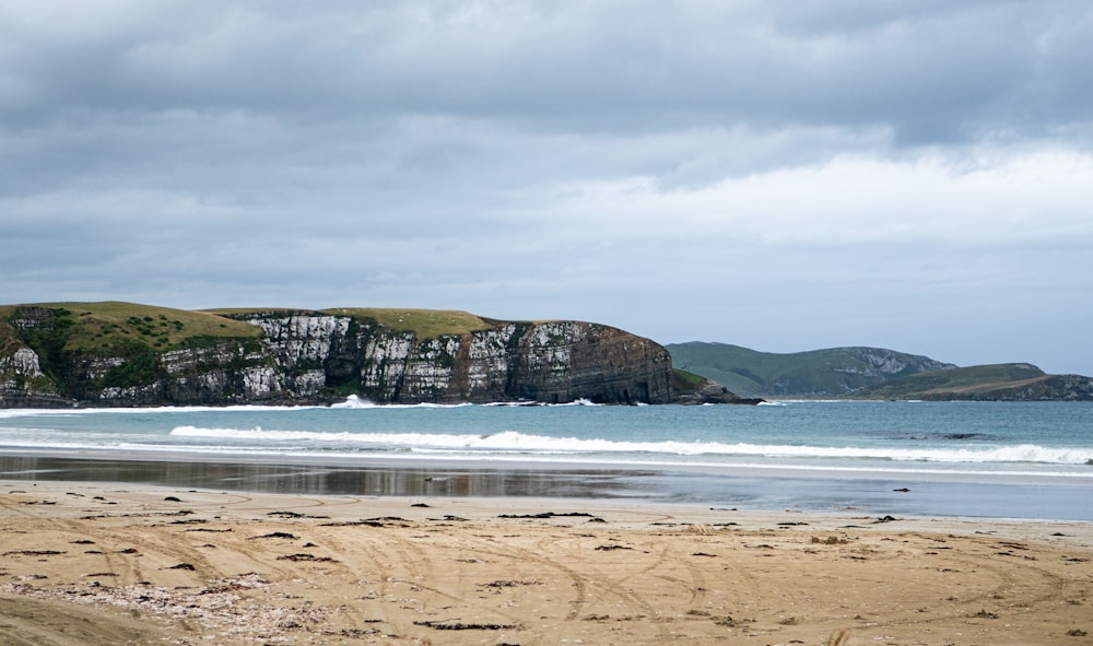 a sandy beach next to a large body of water